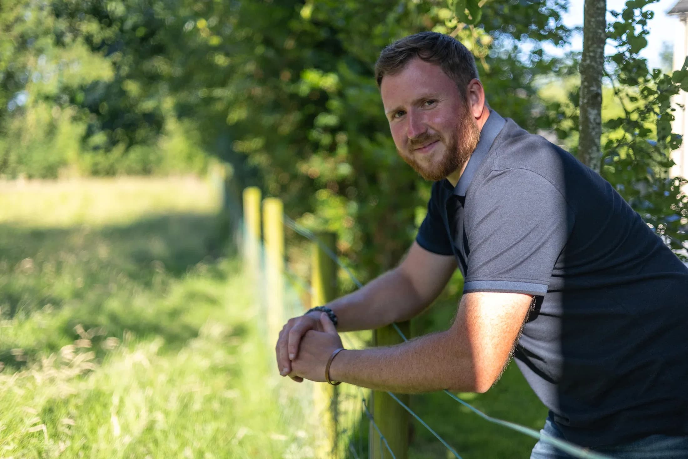 David Falconer looking towards the camera beside a field